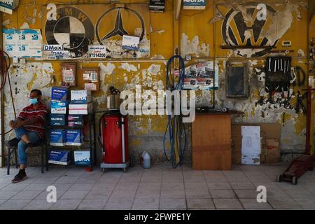 Kuwait City – Kuwait – 15 aprile 2021: Meccanico attende in garage vuoto con parete gialla Foto Stock