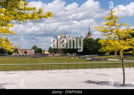 Vista sul prato galleggiante del castello di Schwerin. Il giallo dorato lascia sugli alberi e un cielo drammatico. Foto Stock