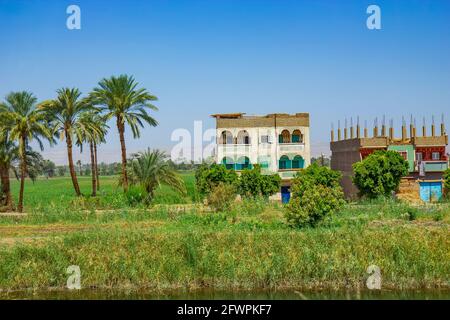 Edifici poveri sul canale del Nilo vicino a Qena, Egitto Foto Stock