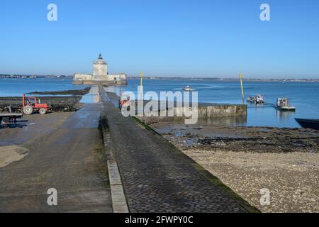 Oyster letti lungo la strada rialzata per lo storico Fort Louvois con le barche di allevamento di ostriche che lasciano il porto a Bourcefranc le Chapus, Charente Maritime, Francia Foto Stock