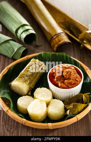 Lemang. Il riso glutinoso viene avvolto con foglie di lerek o di banana racchiuse in culme di bambù e cucinate a fuoco aperto. Foto Stock