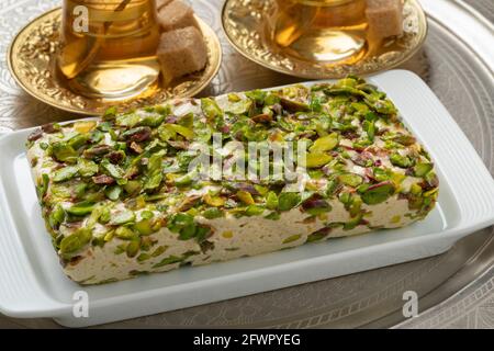 Piatto con tradizionale halva al pistacchio turco da vicino e tè Foto Stock