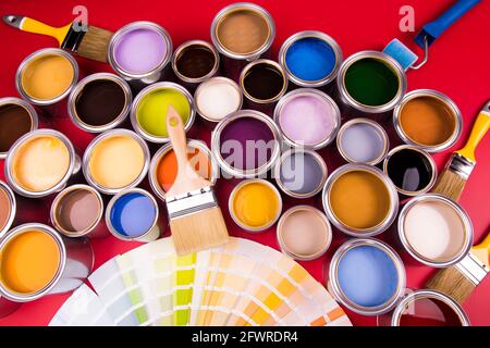 Apri barattoli di vernice con un pennello, colori dell'Arcobaleno Foto Stock