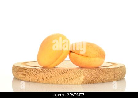 Due succulente albicocche di ananas su un vassoio di legno, primo piano, isolate su bianco. Foto Stock