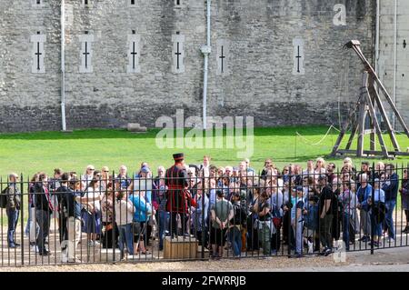 Londra, 19 settembre 2018: Un tour guidato per i visitatori attraverso la Torre. L'uomo in uniforme sul piedistallo di legno racconta ad un grande gruppo l'hist Foto Stock