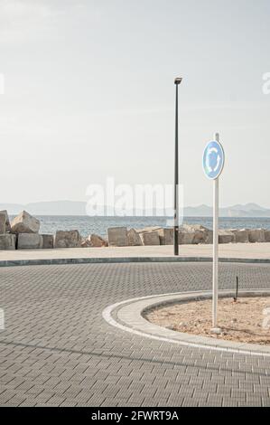 Immagine verticale di un cartello stradale sulla strada che indica una rotatoria Foto Stock