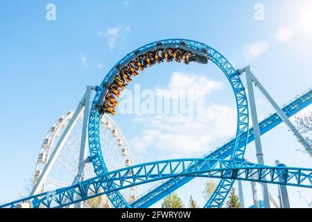 Il trolley di divertimento fa girare il giro del cerchio capovolto, montagne russe Foto Stock