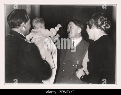 Adolf Hitler e bambino 1939, 'il leader nella cerchia della famiglia Göring' Adolf Hitler saluta Edda Carin Wilhelmine Göring l'unico figlio di politico tedesco, leader militare, e membro leader del partito nazista Hermann Göring, con il suo secondo matrimonio con l'attrice tedesca Emmy Sonnemann Foto Stock