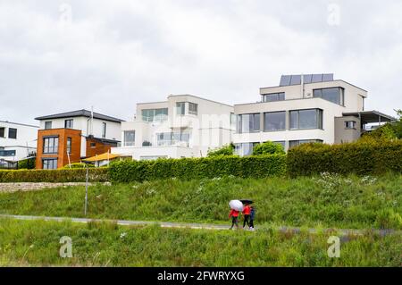 Dortmund, Germania. 24 maggio 2021. Due donne camminano con ombrellone sulla riva del Phönixsee. Oggi, Lunedi di Pentecoste, il tempo nel Nord Reno-Westfalia è per lo più piovoso e nuvoloso. Credit: Jonas Güttler/dpa/Alamy Live News Foto Stock