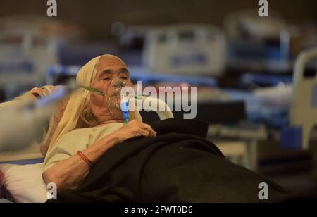 Nuova Delhi, India. 24 maggio 2021. Un paziente Covid-19 che indossa una maschera di ossigeno all'interno di un centro di cura Covid-19 allestito presso la sala banchetti Shehnai adiacente al Lok Nayak Jai Prakash Narayan Hospital (LNJP) uno dei più grandi COVID-19 facilities.India ha registrato 222,315 nuovi casi Covid-19 aggiungendo il paese a 26,751,447 e 4,454 morti negli ultimi 24 ore. Il numero delle vittime dell’India è ora di 303,720. Credit: SOPA Images Limited/Alamy Live News Foto Stock