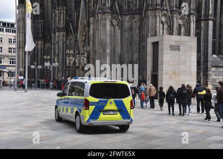 Colonia, Germania. 23 maggio 2021. Un veicolo di emergenza della polizia è parcheggiato di fronte alla cattedrale di Colonia e le persone sono in attesa di essere lasciate nella cattedrale. Credit: Horst Galuschka/dpa/Alamy Live News Foto Stock
