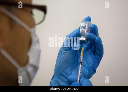 Tokyo, Giappone. 24 maggio 2021. Il personale medico prepara i vaccini Moderna coronavirus da utilizzare presso il centro di vaccinazione di massa di recente apertura. Con uno dei tassi di vaccinazione più bassi del Covid-19 nel mondo sviluppato e con i Giochi Olimpici di Tokyo a poco più di due mesi di distanza, le autorità giapponesi hanno aperto siti di vaccinazione di massa a Tokyo e Osaka nel tentativo di promuovere la loro campagna di inoculazione del coronavirus. Credit: Carl Court-POOL/ZUMA Wire/Alamy Live News Foto Stock