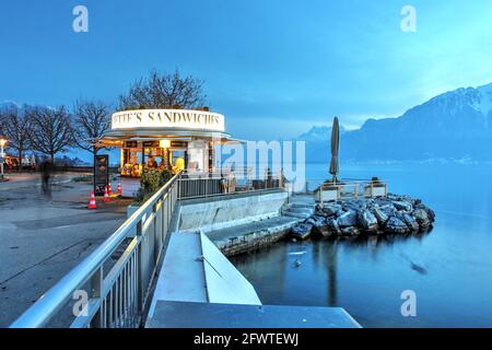 Serata invernale lungo il lungomare promendade di Vevey, Svizzera, con boutique art-deco, panini Babette che servono dolci serpenti a visito Foto Stock