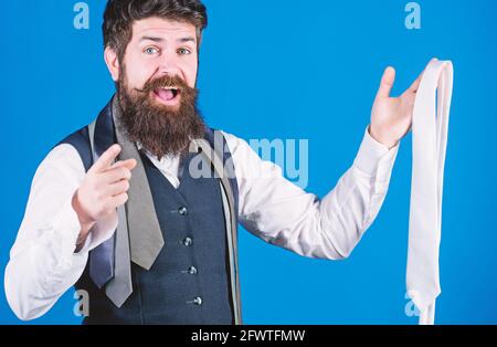 È necessario acquistarlo. Acquista l'assistente che punta il dito e offre un ampio assortimento di cravatte da acquistare. Uomo bearded felice sorridente con personale Foto Stock