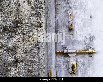 Muro rovinato e vecchio dispositivo di chiusura della porta arrugginito Foto Stock