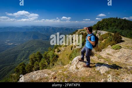 Escursionista che guarda i Pirenei orientali dalla Serra del Catllaràs in estate (Berguedà, Barcellona, Catalogna, Spagna, Pirenei) Foto Stock