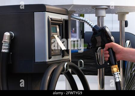 Pompa della stazione di servizio. L'uomo riempie la sua auto con una benzina alla stazione di benzina. Per riempire automaticamente con carburante. Benzina e prodotti petroliferi. Foto Stock