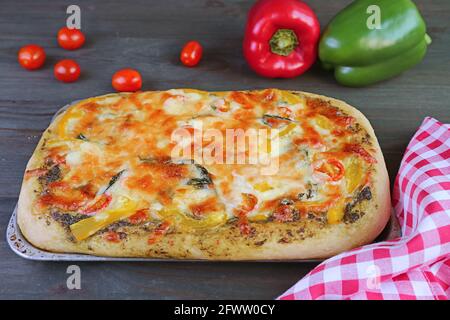 Pizza appena sfornata con deliziosa salsa di pesto con verdure caserecce il tavolo Foto Stock