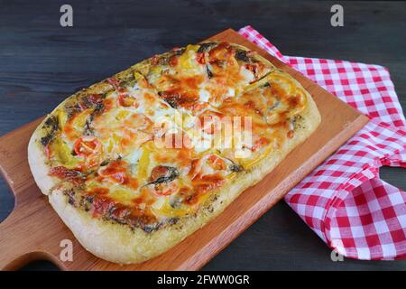 Appetitoso pesto vegetariano fresco cotto in casa pizza su un legno breadboard Foto Stock