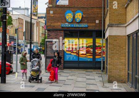 Slough, Berkshire, Regno Unito. 23 maggio 2021. Gli amanti dello shopping oggi a Slough High Street. Il tasso di infezione da rotolamento di sette giorni Covid-19 per 100,000 persone in Slough per la settimana che termina il 18 maggio è salito a 25.4, rispetto a 22.7. Dato che il numero di casi positivi di variante indiana di Covid-19 sta iniziando ad aumentare, la possibile eliminazione di tutte le restrizioni di blocco a giugno potrebbe ora essere in pericolo. Credito: Maureen McLean/Alamy Foto Stock