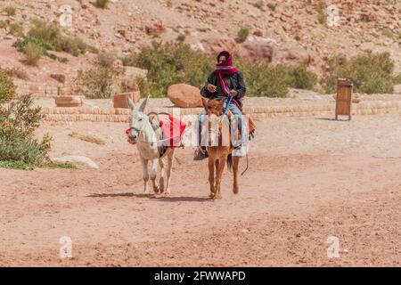 PETRA, GIORDANIA - 23 MARZO 2017: Ciclista locale dell'asino nell'antica città di Petra, Giordania Foto Stock