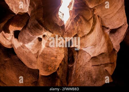 interno di una grotta attraverso la quale un raggio di luce filtra, erose rocce di arenaria Foto Stock