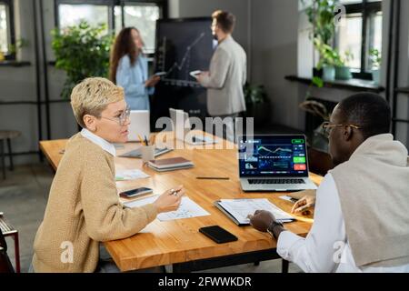 Due economisti discutono dei dati finanziari durante la riunione in carica Foto Stock