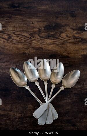 primo piano di 5 cucchiai giacciono su un tavolo di legno nella forma di una ventola Foto Stock