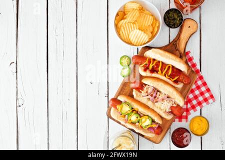 Varietà di hot dog barbecue. Sopra il bordo laterale della scenografia del tavolo sopra uno sfondo di legno bianco. Spazio di copia. Foto Stock