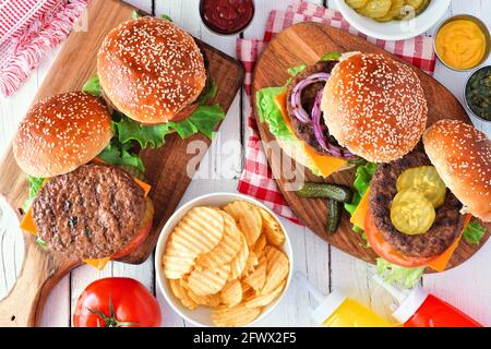 Barbecue hamburger scena tavolo. Vista dall'alto su uno sfondo di legno bianco. Foto Stock