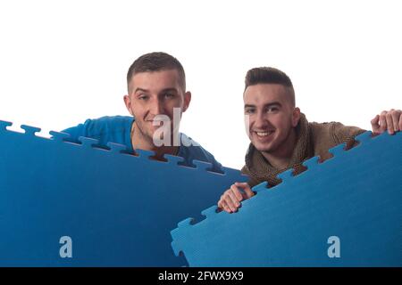 Young Men Holding Blue Tatami Mat Puzzle - isolato su Sfondo bianco Foto Stock