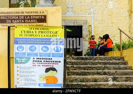 Churchgoers che indossano maschere di fronte alla chiesa, Merida Messico Foto Stock