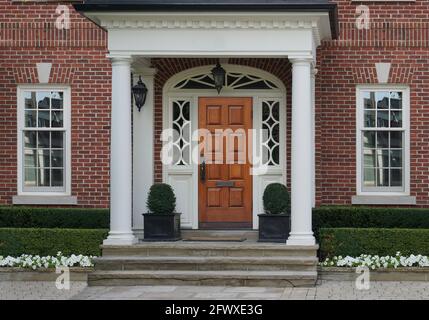 Elegante ingresso casa con porta in legno e portico Foto Stock