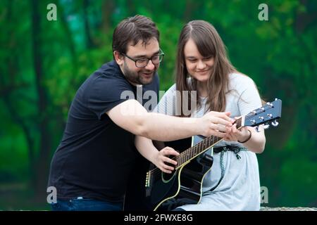 Fratello insegnava a suonare la chitarra in natura Foto Stock