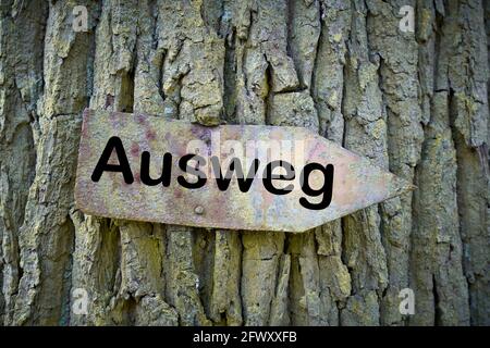 Vecchio segno arrugginito con l'iscrizione via d'uscita (Ausweg) un albero Foto Stock