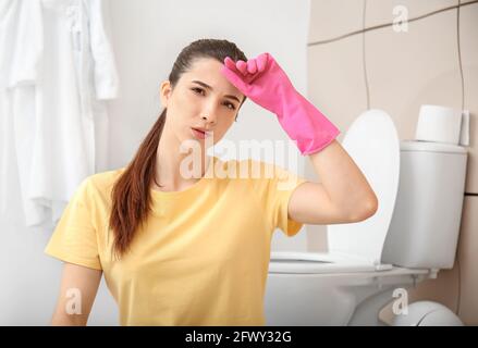 Giovane donna che riposa dopo aver pulito il suo bagno Foto Stock