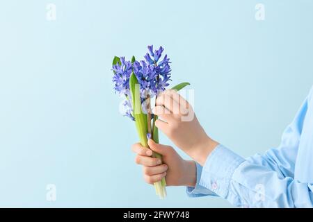 Donna che tiene bellissimi fiori di giacinto su sfondo colorato Foto Stock