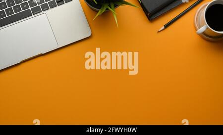 Vista dall'alto del tavolo giallo con spazio per la copia, computer portatile, cancelleria, caffettiera e pentola, scena creativa Foto Stock