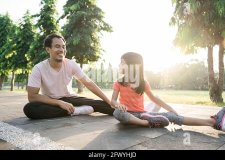 padre e piccola figlia fanno esercizi all'aperto. Stile di vita sano della famiglia con il bambino Foto Stock