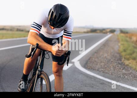 Rilassante ciclista in abbigliamento sportivo seduto in bicicletta all'aperto Foto Stock