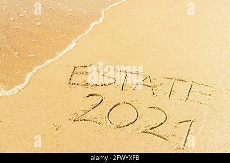 Tenuta 2021 scritto sulla sabbia di una spiaggia con onde di lavaggio, cancellandolo o cancellandolo durante l'estate di Coronavirus, Covid libero, spiaggia sicura, vaccino Foto Stock