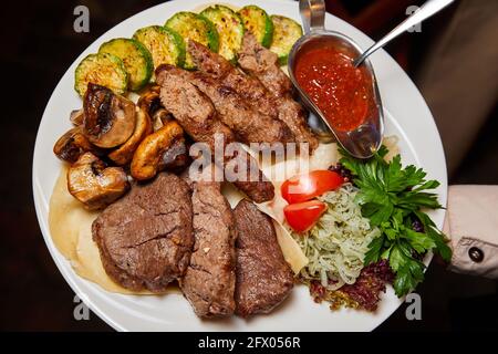 Manzo lula kebab e shish kebab con verdure alla griglia. Primo piano, messa a fuoco selettiva Foto Stock
