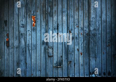 Porta da garage in metallo blu indossata con ruggine e segni di graffio per sfondo, vecchia grana Foto Stock
