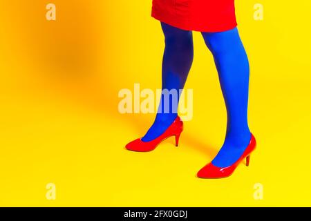 Vista laterale del prodotto modello femminile non riconoscibile con scarpe brillanti e collant in studio vivace Foto Stock