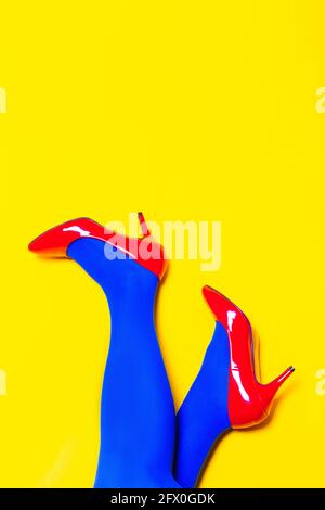 Da sopra del raccolto modello femminile irriconoscibile che indossa scarpe brillanti e collant in studio vivace Foto Stock