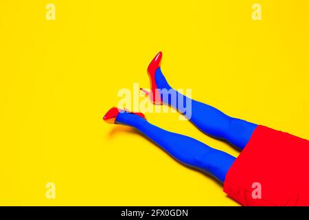 Da sopra del raccolto modello femminile irriconoscibile che indossa scarpe brillanti e collant in studio vivace Foto Stock
