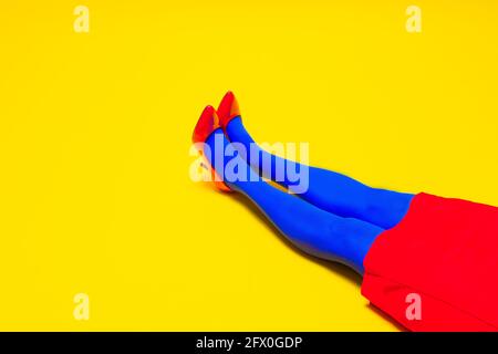 Da sopra del raccolto modello femminile irriconoscibile che indossa scarpe brillanti e collant in studio vivace Foto Stock