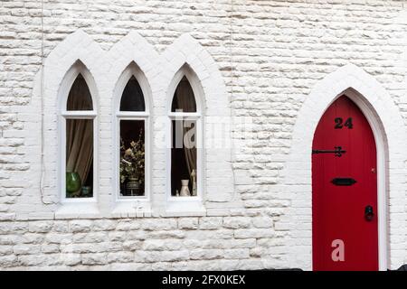 Facciata di un cottage in pietra imbiancato con finestre e porte in stile gotico, Stony Stratford, Buckinghamshire, Regno Unito Foto Stock