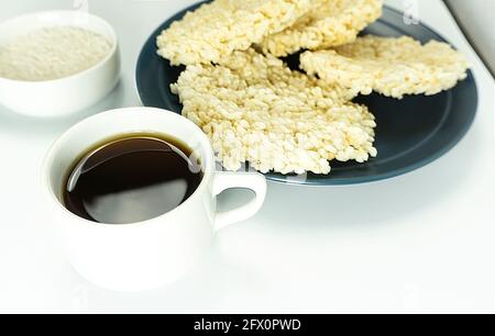 Rengginang o patatine a base di riso glutinoso tradizionale indonesiano servito su un piatto di ceramica con una tazza di caffè Foto Stock