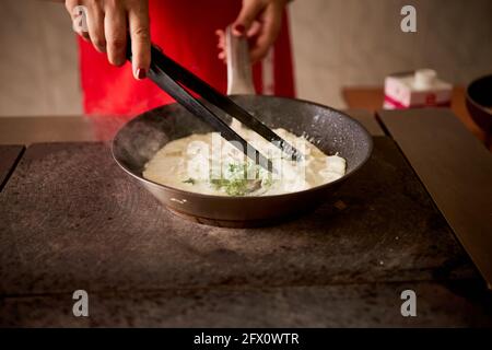 mescolare gli spinaci verdi in una salsa di padella Foto Stock